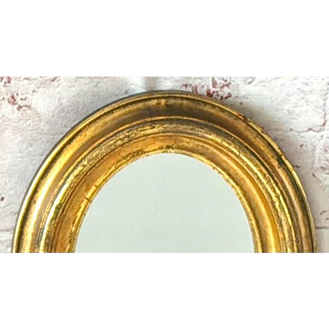 Elegant 19th Century English Regency Oval Giltwood Wall Mirror. Mirror is hand-carved in wood and finished with gilding....