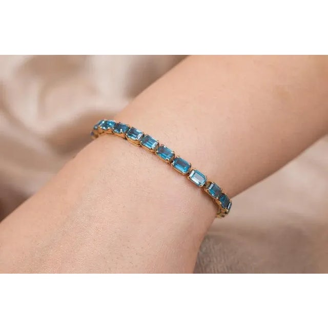 This is part of Chairish’s Fine Jewelry assortment. This 18.5 ct Blue Topaz Tennis Bracelet in 18K gold showcases 25...
