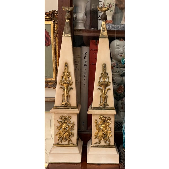 Pair antique 18th century French Louis XVI / Directoire white marble obelisks with gilt bronze trophy mounts. Each capped...