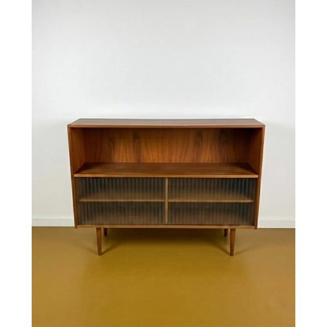 Vintage 1950s Danish teak low bookcase with sliding pleated glass doors, an elegant design perfect for mid-century decor....
