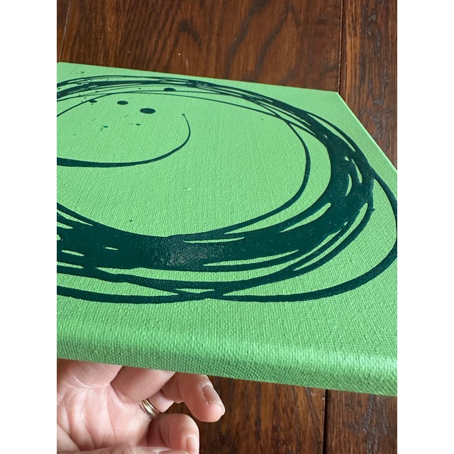 This is a warm pistachio green canvas with a textural hunter green circle pattern and a few paint splatters / drips that...