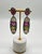 Earrings featuring multicolored sapphires set in a vertical arrangement of 57.23 carats. The top stone is a deep pink,...