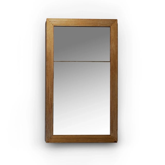 A tall, narrow French fluted giltwood pier mirror with original mercury plate. The fluted giltwood frame with rich patina...