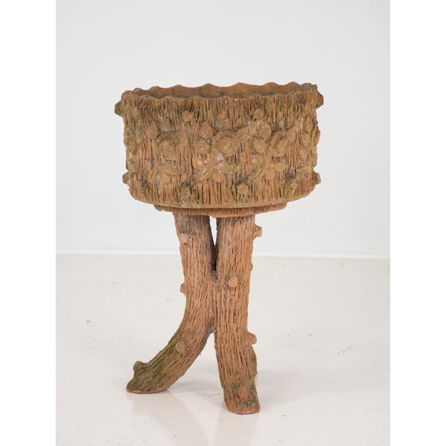 An unusual terracotta planter in a Faux Bois style. The base of the plant stand has three legs all designed with classic...