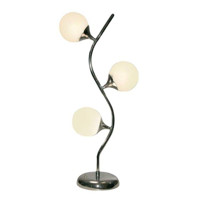 Post-modern vine-like table lamp in the manner of Robert Sonneman features three illuminated glass globes affixed to a...