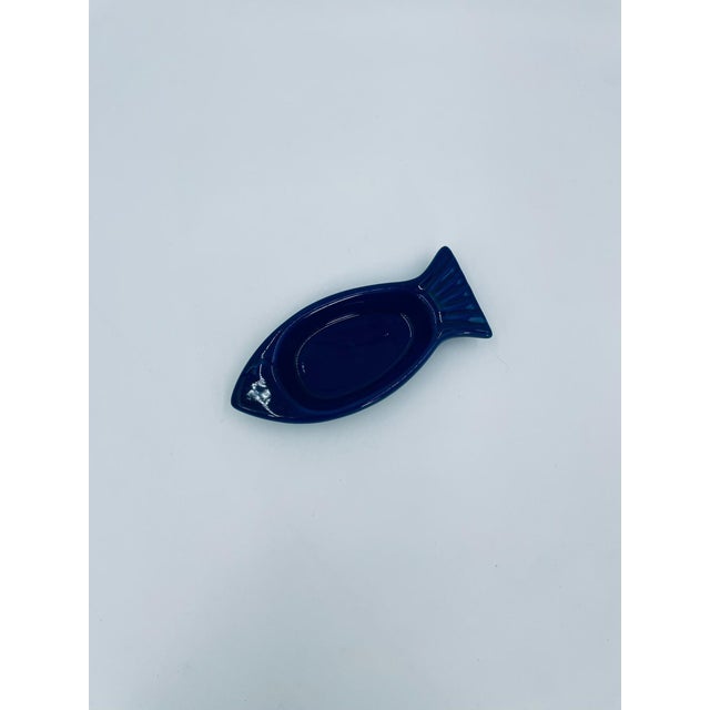 A small vintage-style snack bowl made of high-quality ceramic. The bowl is shaped like a fish and is stained a deep cobalt...