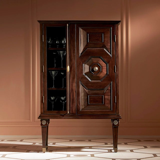 Mahogany bar cabinet in walnut distressed finish, with antique brass details and hardware. Featuring three shelves on the...