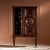 Mahogany bar cabinet in walnut distressed finish, with antique brass details and hardware. Featuring three shelves on the...
