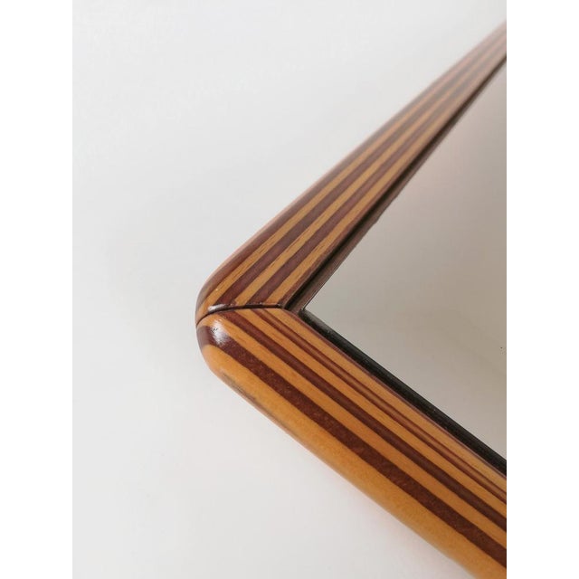 A mirror of high quality and precious workmanship. It was made in Italy in the late 70s. The two-tone solid walnut wood...