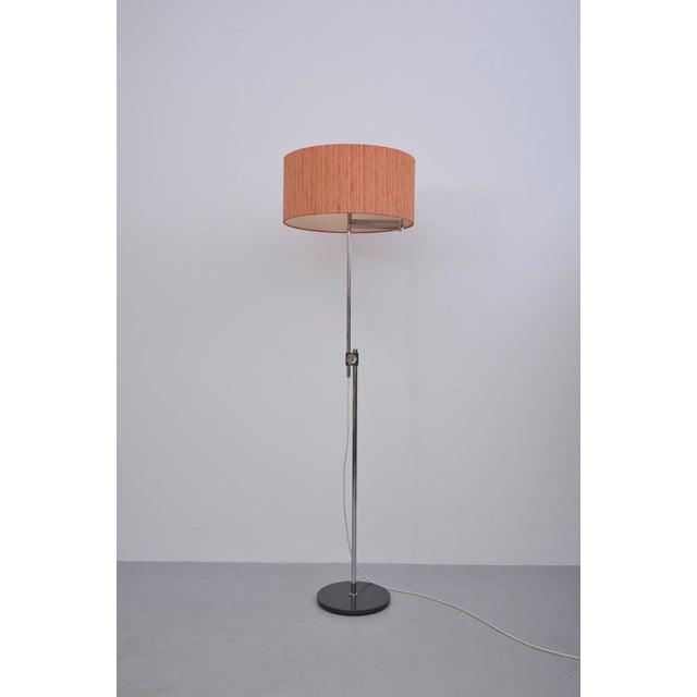 Floor lamp by Kaiser Leuchten, made in Germany. Height-adjustable floor lamp with a red fabric shade. The lamp's height is...