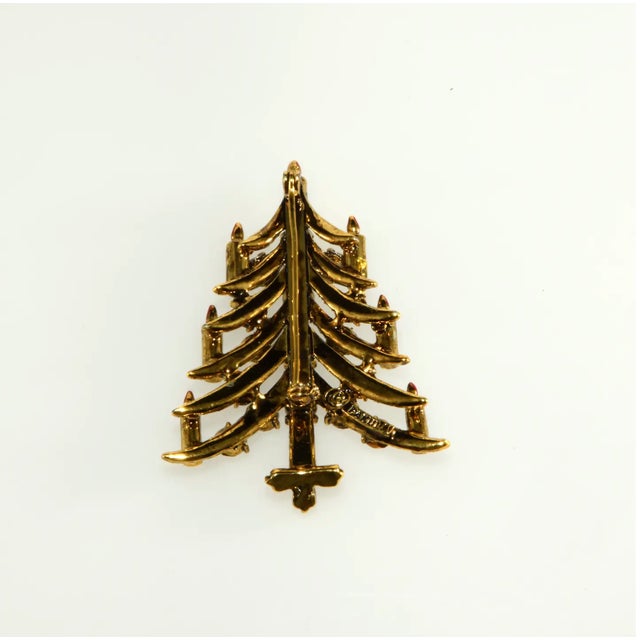 Christmas tree pin with clear rhinestone baguette candles and red enameled flames. Other accents include clear round...