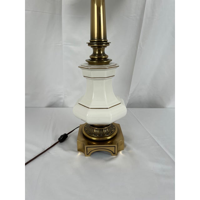 Vintage Stiffel table lamp, with brass bases and columns, and octagonal urn-form white porcelain bodies. Gilt trim to...
