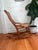 Vintage early 20th century Colonial Revival rocking chair featuring a hand-caned seat and back with a decorative burlwood...