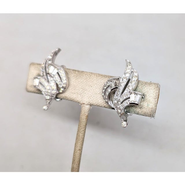 Circa 1960s rhodium plated round and baguette clear rhinestone clip earrings. Marked "PANETTA" on the clips. Measure: 1...