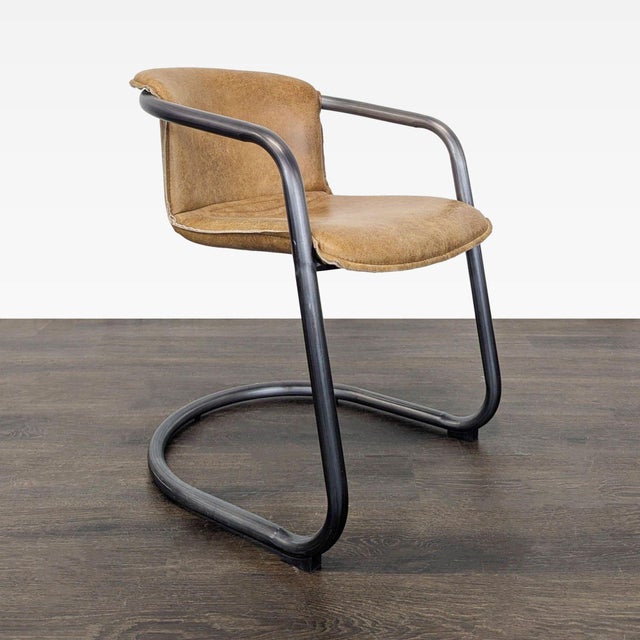 This lounge chair features a sturdy black metal frame with a curved base for stability and modern style. The seat and...