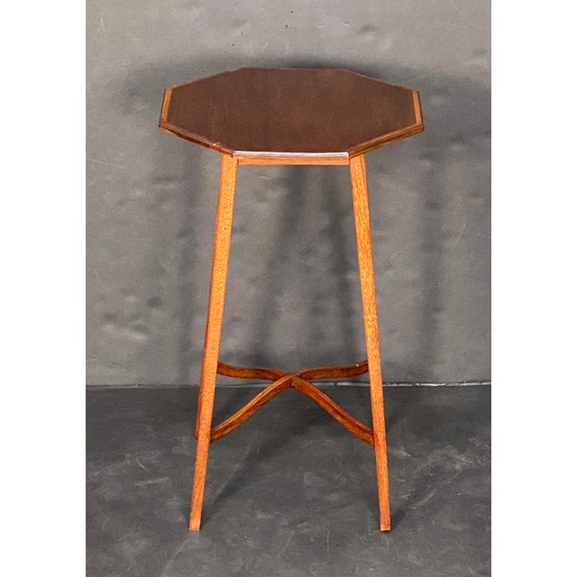 A fine English occasional table of mahogany from the Edwardian era, featuring a moulded octagonal top with an inlay around...