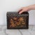 Antique Japanese black lacquer Meiji period box. There is a beautiful hand-painted scenic detail on the top of the box.