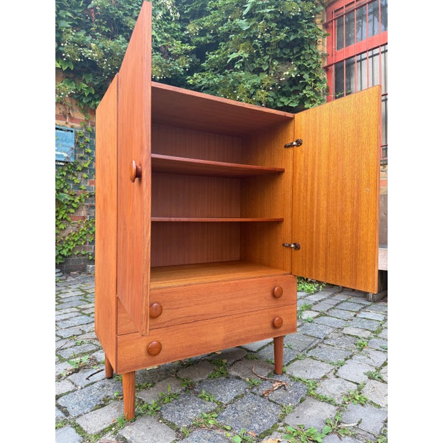 A masterful example of Scandinavian craftsmanship: This compact teak chest of drawers brings timeless Danish mid-century...
