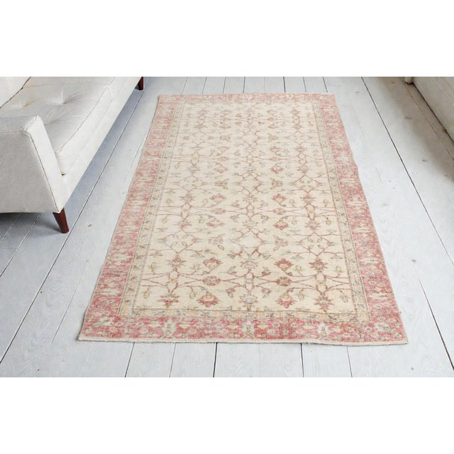 This is a vintage Turkish Oushak rug from the Mid 20th Century. The piece was hand-knotted.