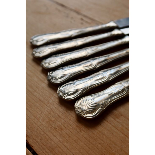 This vintage cutlery set, consisting of forks and knives, features beautiful handles decorated with a detailed floral...