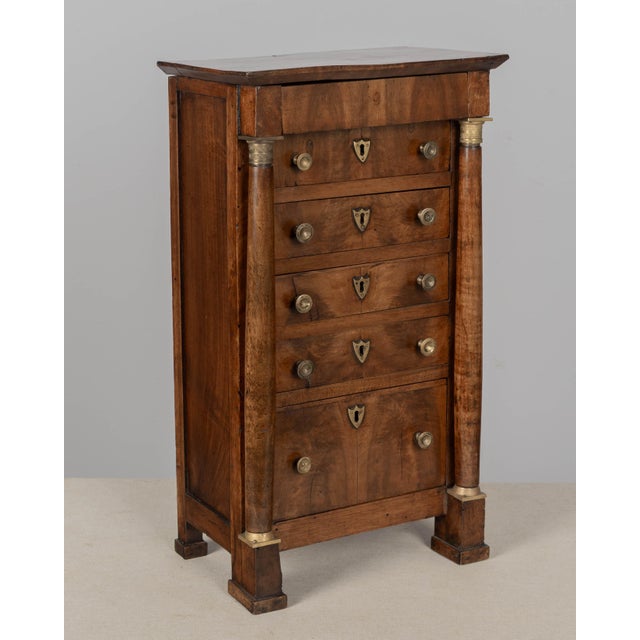 An early 19th century French Empire Period miniature semainier chest finished in rich matched flame walnut veneers....
