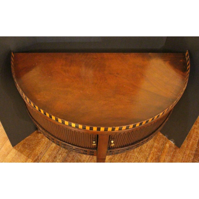 Circa 1800 Dutch demilune side or console table, Neo-classical. Mahogany with tambour doors above a fretwork apron, below...