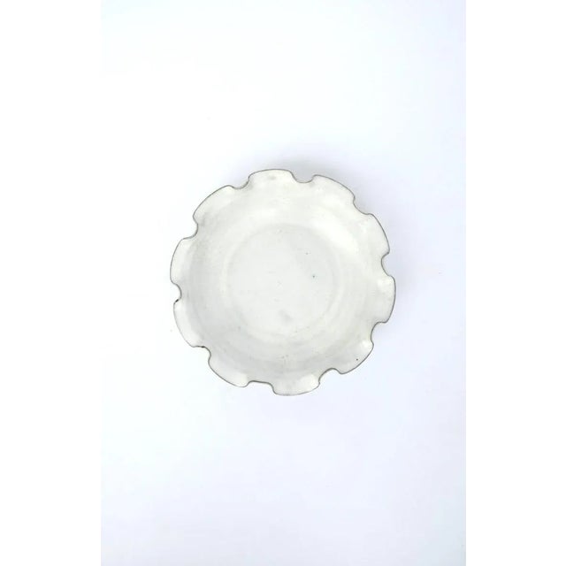 A beautiful white pottery bowl with ruffled edge. Great as a standalone piece, as a catch-all, or serving bowl....