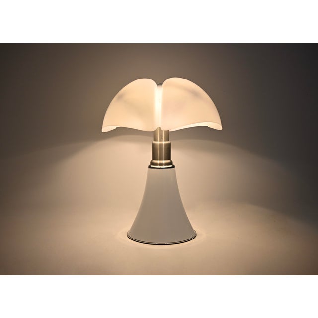White metal and plastic lamp by Gae Aulenti. Adjustable height: min: 70cm max: 85cm. Stamped under the lamp. Wear...