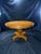 A striking vintage round dining table featuring a richly figured burl wood finish, decorative geometric inlay, and an...