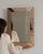 Carved wood mirror in Warm Blush Pink. The warm blush pink surface highlights fine relief-carved frame, soft blush-toned...