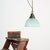 A vintage bell pendant glass light manufactured by ‘holophane’ in an unusual blue glass colour variation. The light has an...
