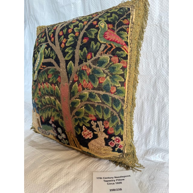 This 17th century English needlepoint pillow is worked in wool and silk and features a richly detailed orchard scene...