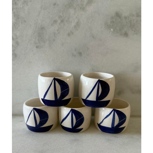 Set of 5 white ceramic napkin rings with blue sailboat on either side. Cute addition to your next nautical themed dinner!