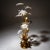 Sheet metal floor lamp with gold-patinated leaves and white enameled flowers. The lamp sockets are located in the calyxes....