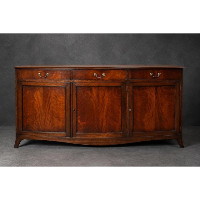 Elegant antique bow-front sideboard crafted in richly toned mahogany, featuring a beautifully curved façade and refined...