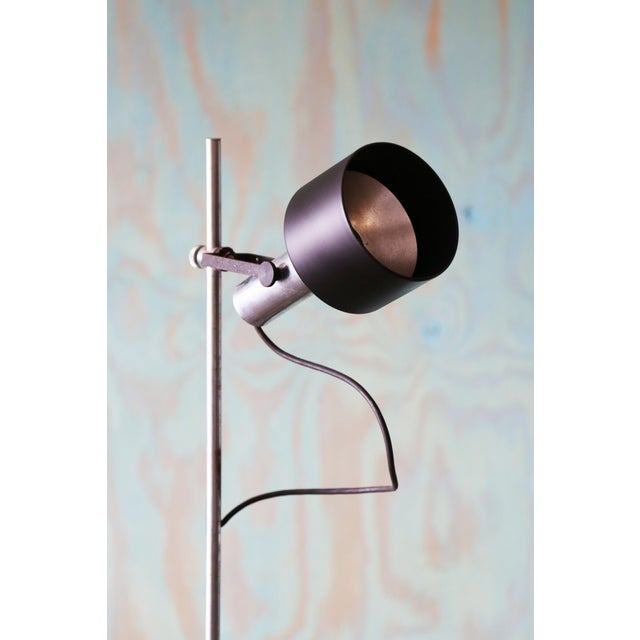 A 1960s adjustable and directional spot light floor lamp designed by Gerald Thurston for Lightolier. in a chrome and black...