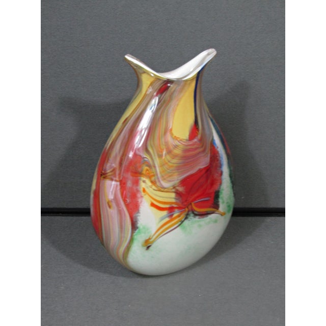 A substantial hand-blown art glass vase with a dramatic sculptural profile and vibrant Murano-inspired palette. The...