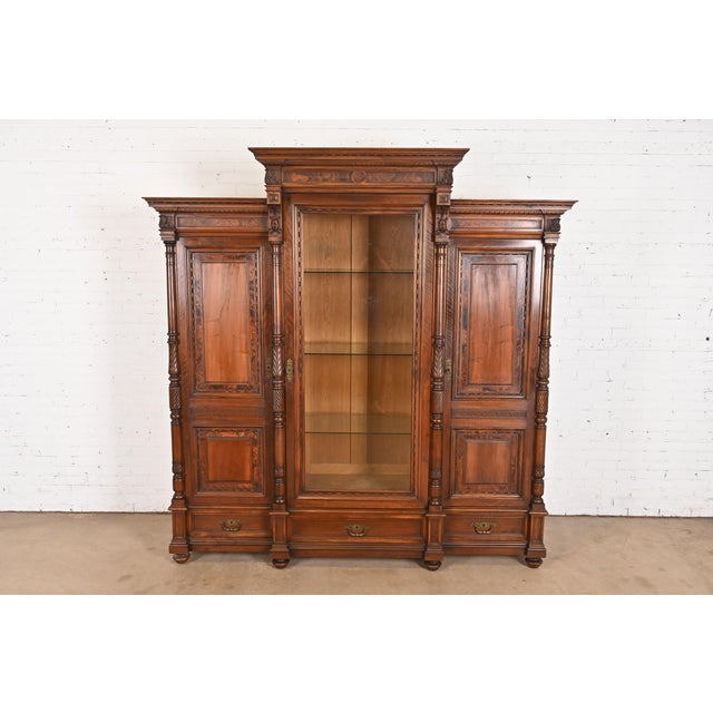A gorgeous monumental antique Eastlake Victorian or Renaissance Revival triple bookcase cabinet or armoire In the manner...