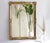 A large vintage rectangular mirror with gold gilt wood details. The mirror is made in Belgium and has a brand in the back....
