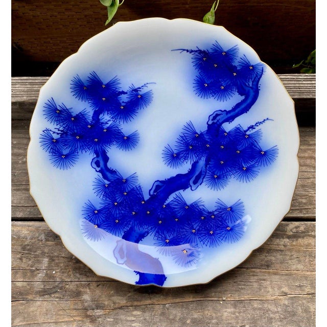 Striking vintage Japanese porcelain charger featuring an elegant white ground with flowing cobalt blue pine boughs...