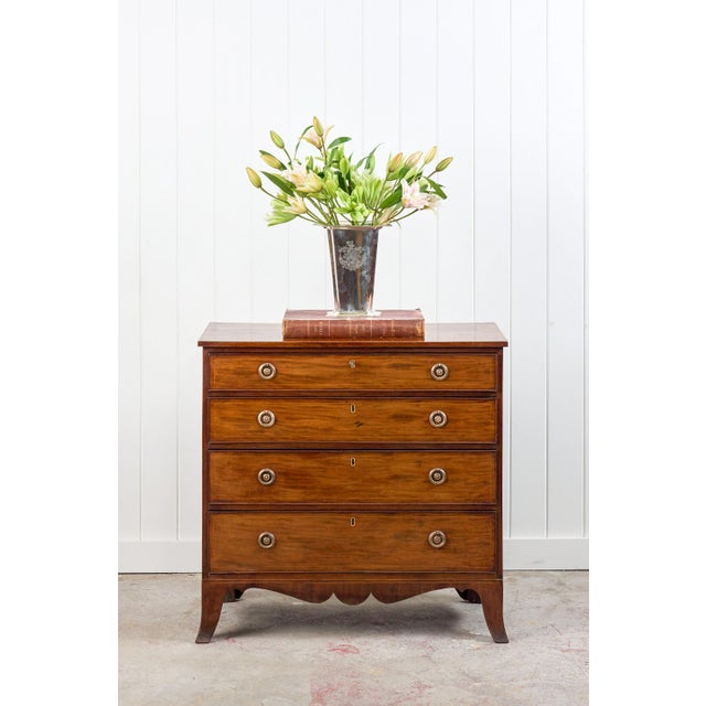 This 19th-century English mahogany chest features warm, medium-toned mahogany, four drawers with brass ring pulls and...