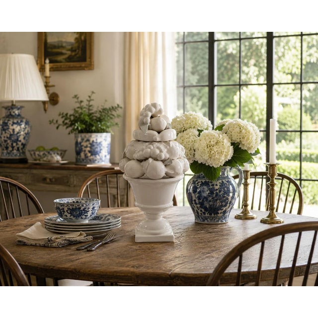 An elegant mid-20th century white glazed ceramic fruit topiary featuring an abundant arrangement of sculpted fruit...