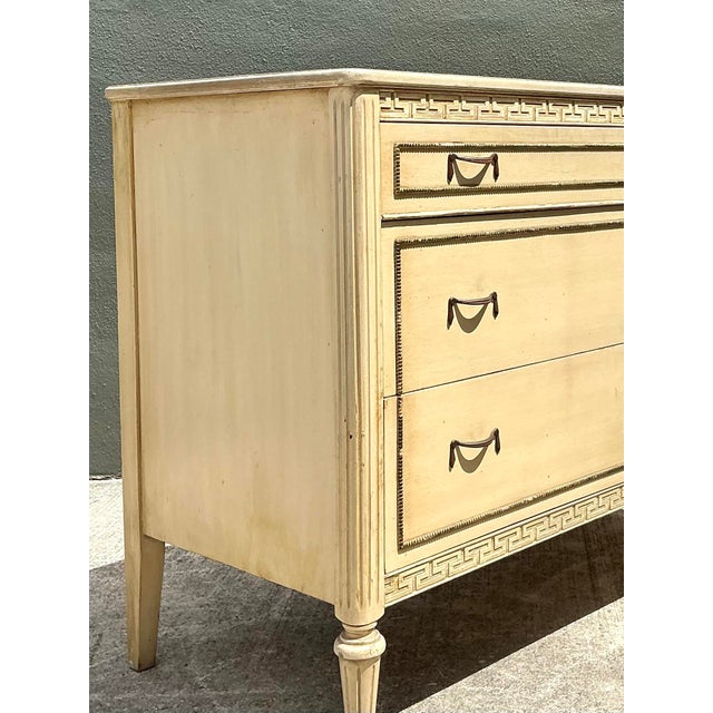This elegant vintage chest of drawers is a masterful blend of Neoclassical structure and Hollywood Regency flair. The...