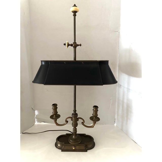 An exquisite Bouillotte lamp by Frederick Cooper, circa 1970s. Features a brass frame with two candlestick lights over an...