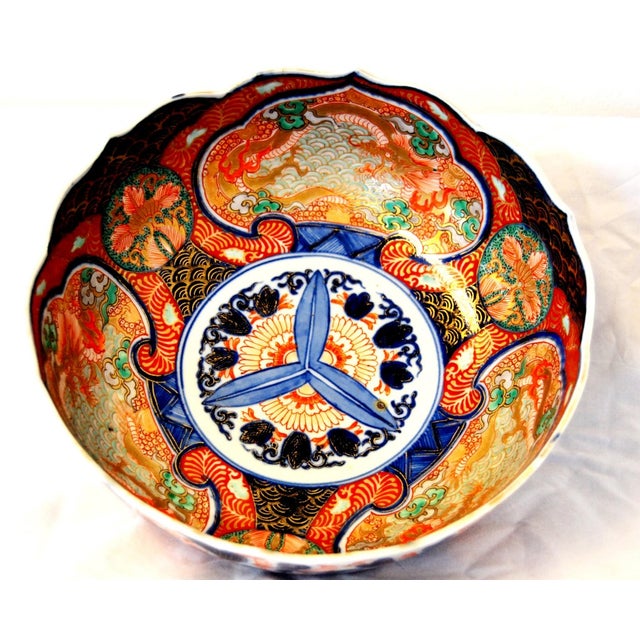 A late Meiji period Japanese Imari porcelain bowl with scalloped edges, interior decoration with Dragon vignettes and...