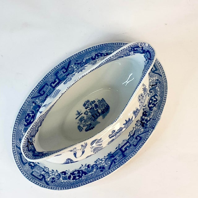 We have here a Blue Willow Antique Gravy Boat from Ridgway Porcelain out of England. The piece has an attached under...