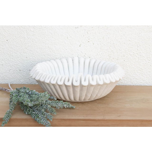 Carved from a single block of pristine white marble, the vessel has been meticulously hand-chiseled to create a continuous...