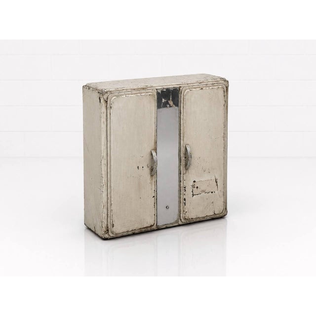 A characterful French medicine cabinet made of lacquered metal with an authentic industrial patina from the 1940s. This...