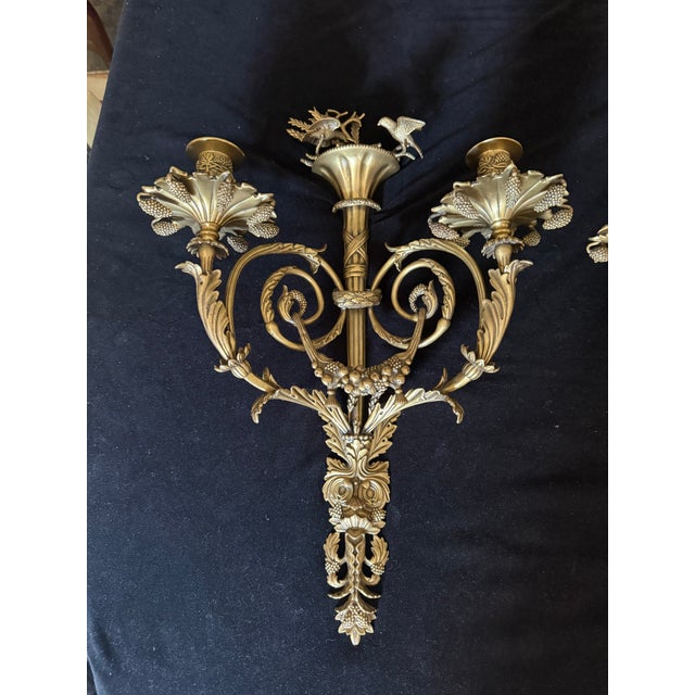 Ornate and rare pair of heavy solid brass finely detailed two arm candle sconces handmade by Decorative Crafts Inc. The...