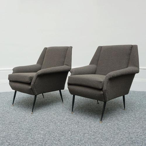 A pair of mid-century angular armchairs. Original brass capped steel feet. Re-upholstered in grey bouclé. Dimensions: h...